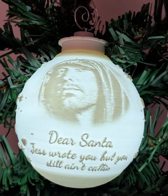 Eminem lithophane bauble, lit from inside, hanging on a Christmas tree with "Dear Santa" lyric text